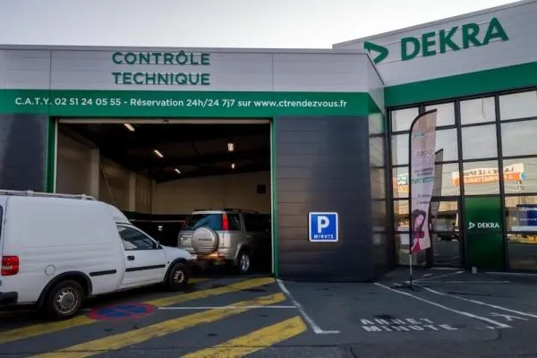 Entrée du centre de contrôle technique DEKRA avec véhicules en attente de contrôle